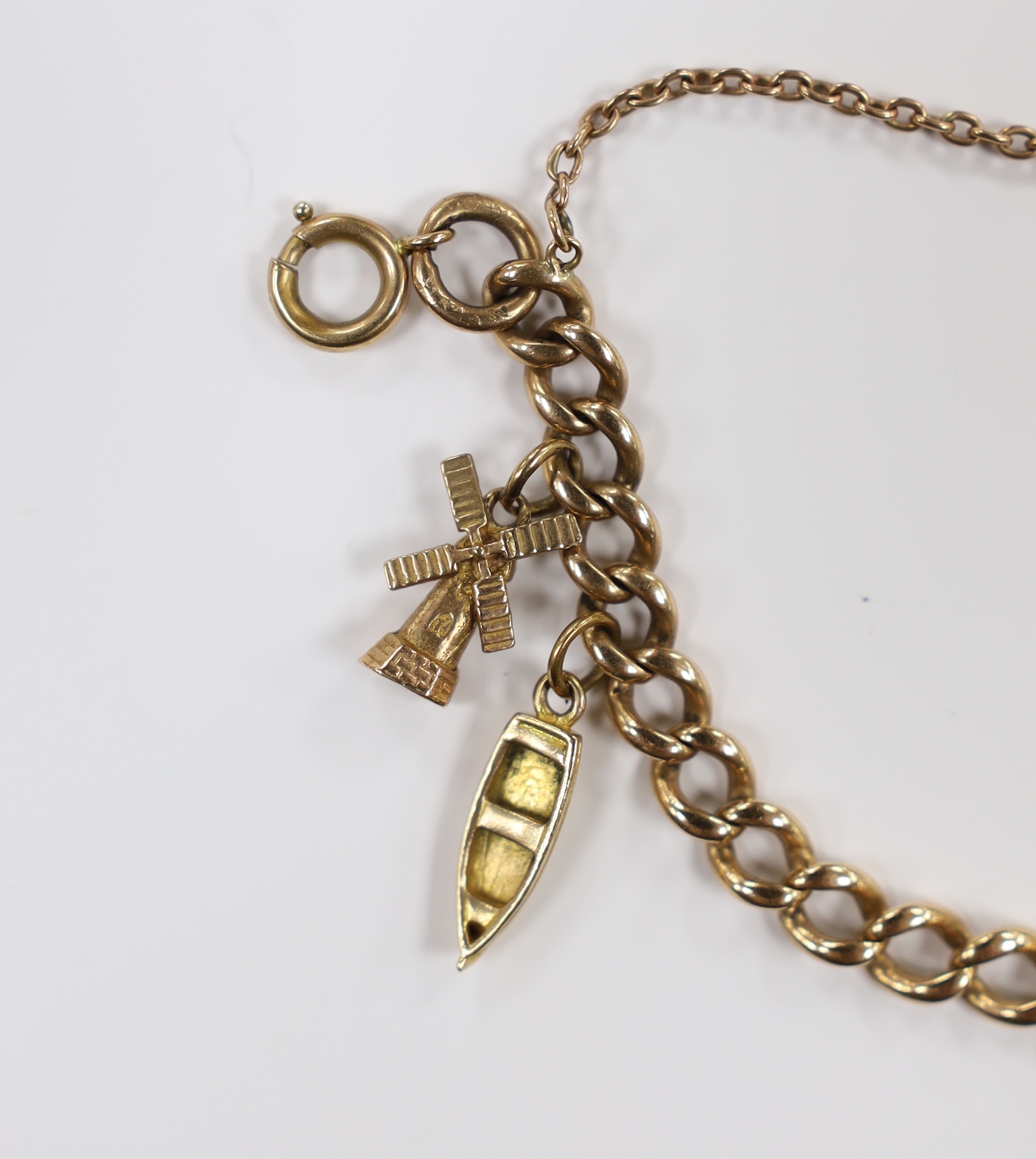 A 9ct curb link charm bracelet, hung with six assorted charms, including five 9ct gold, gross weight 19 grams.